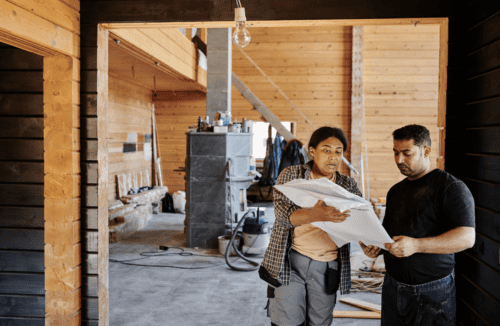 Construction Workers and woman on construction project reviewing plans