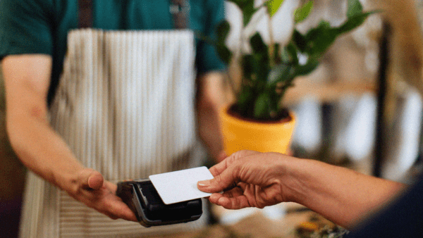 A business transaction including a person scanning card on card reader