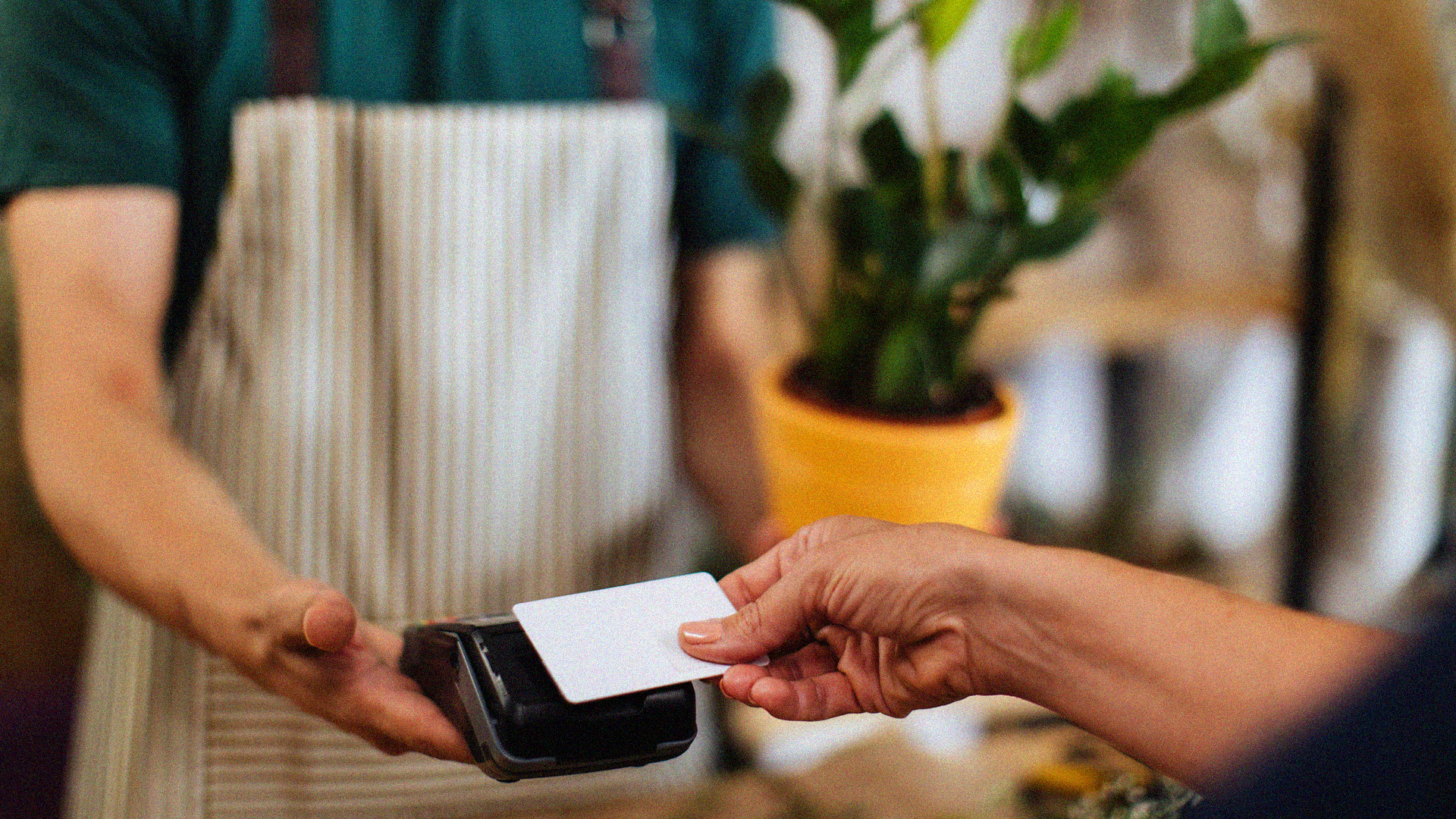 A business transaction including a person scanning card on card reader