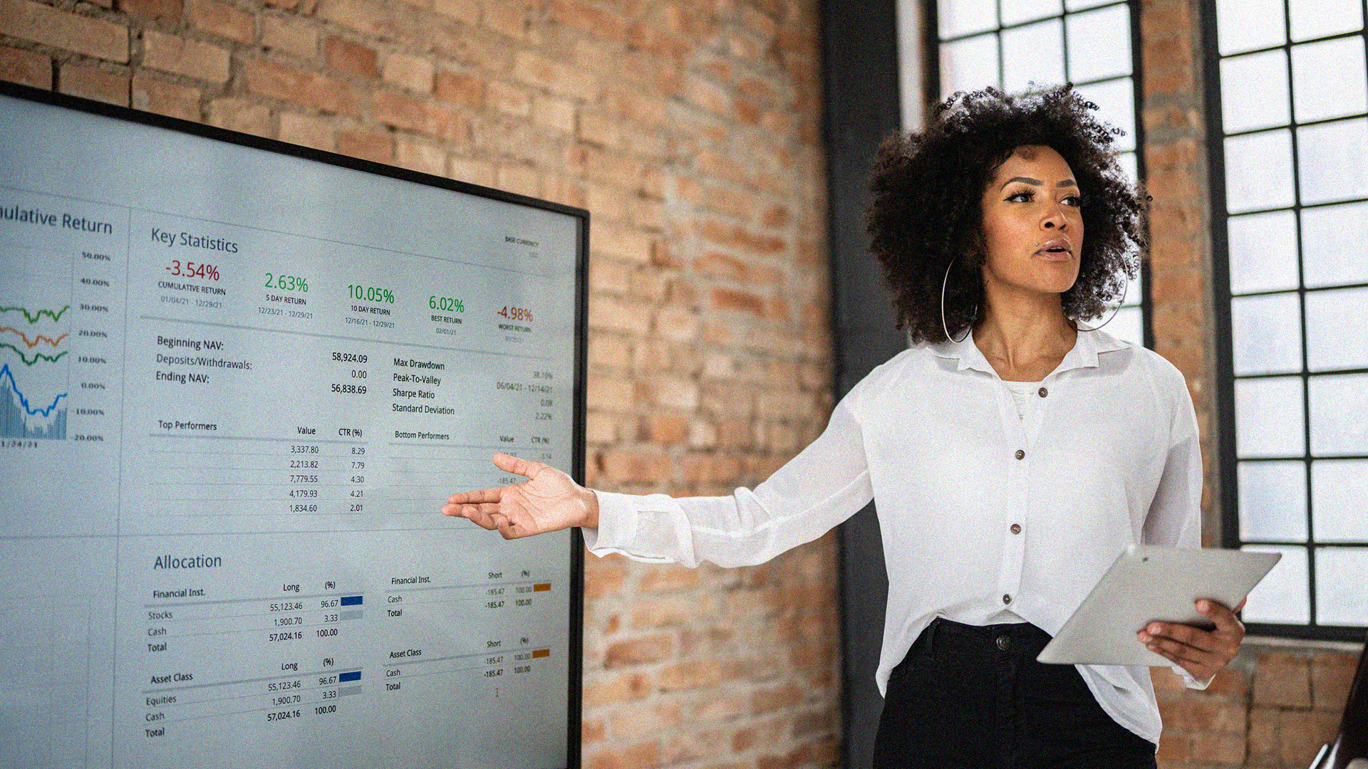 Woman holding ipad giving a presentation pointing at stats