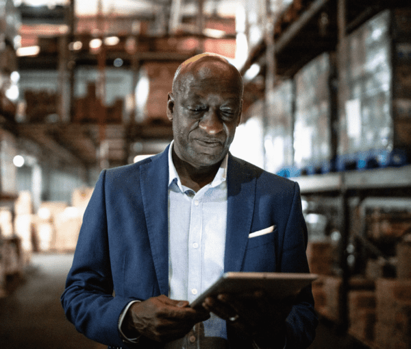 businessman looking at Ipad in warehouse