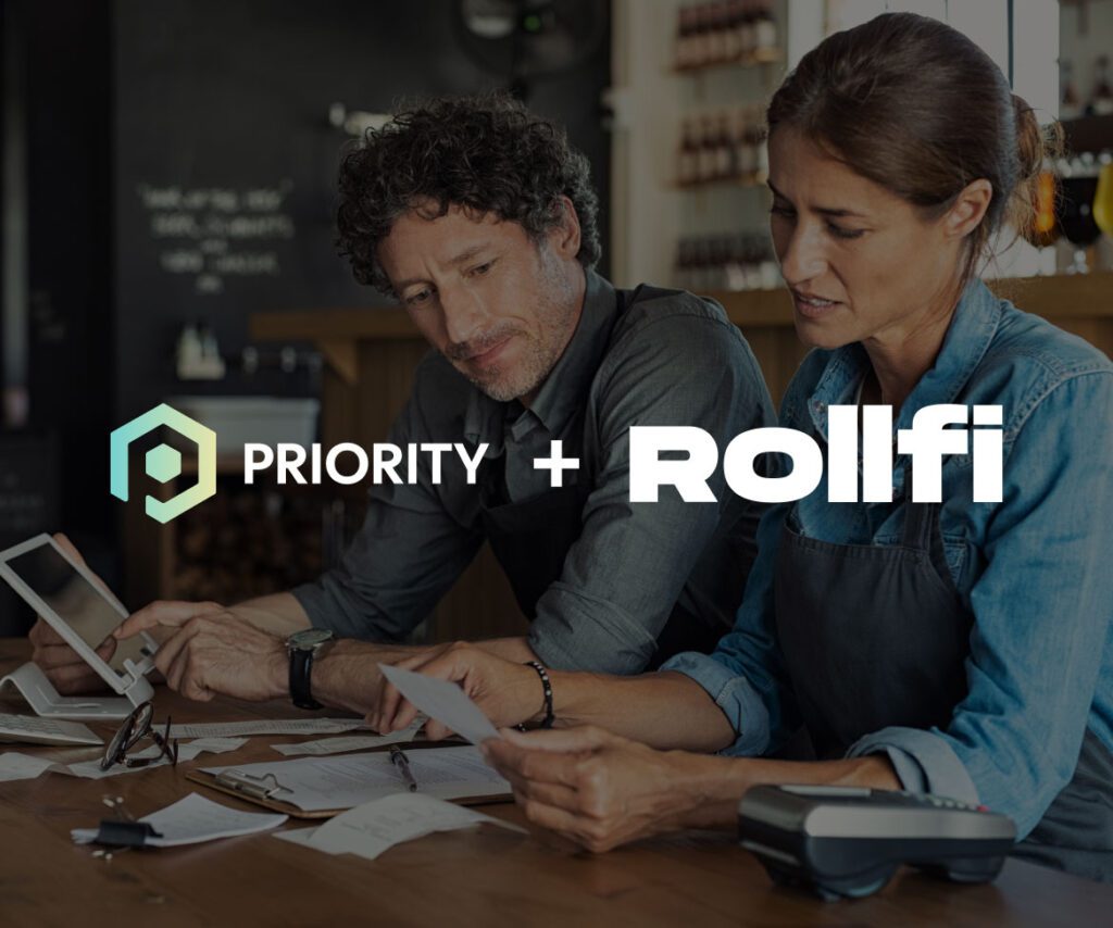 Two small business owners reviewing receipts and using a tablet at a wooden table, with payment processing equipment nearby. Overlaid logos read "Priority + Rollfi," indicating a business partnership or acquisition.