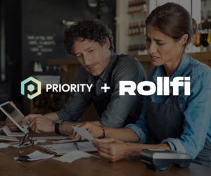 Two small business owners reviewing receipts and using a tablet at a wooden table, with payment processing equipment nearby. Overlaid logos read "Priority + Rollfi," indicating a business partnership or acquisition.