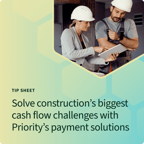Two construction workers looking at a tablet device for payment solutions