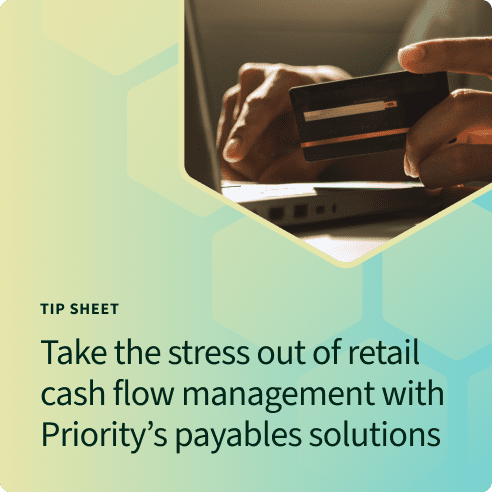 Hands holding a credit card and typing into a laptop for payables solutions