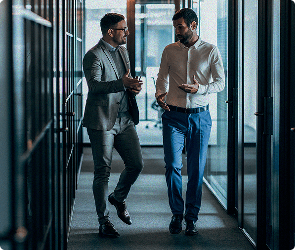 Two males in an office setting walking down the hall