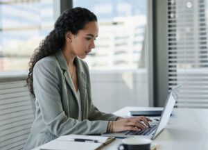 Business professional working on a laptop in a modern office, representing secure fintech platform operations and customer trust.