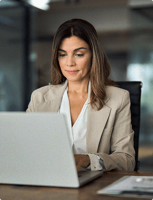 Woman sitting at a desktop working on a laptop