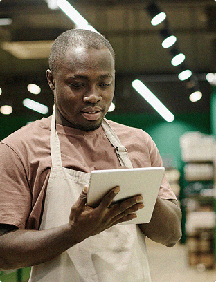 Man wearing an apron working on a tablet device