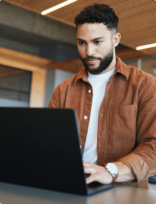 Man standing in front of a desk on laptop