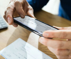 Person using a smartphone to deposit a check via mobile banking app.