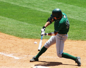 Baseball player swinging a bat, illustrating college athlete name, image, and likeness (NIL) compensation.